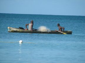 fishermen row beyong the reef to spread their nets