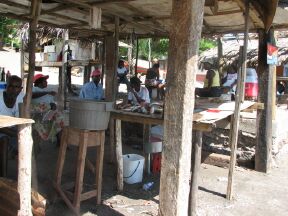 Men wait patiently for the fish or shrimp to be weighed and cleaned